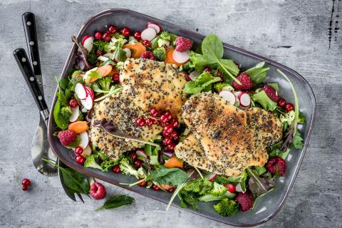 Breaded chicken breast on a berry salad