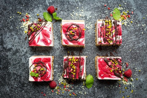 Tranci di cheesecake cruda con lamponi e cioccolato
