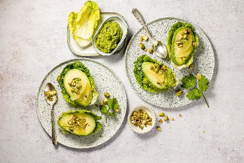 Pea hummus with pistachios and avocado on lettuce hearts