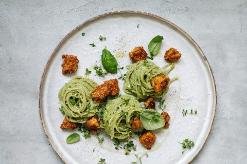 Spaghetti cremosi al pesto con croccante di arachidi